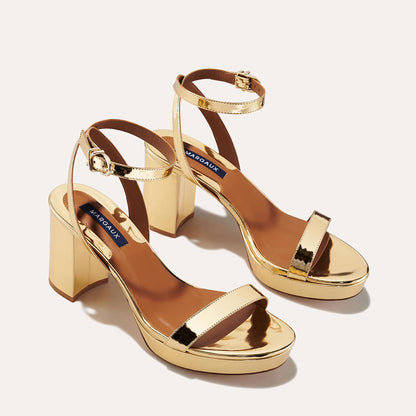 The Stella Platform in Gold Mirror, featuring a sleek strap across the toes and a comfortable 3.5-inch block heel and platform.