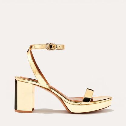 The Stella Platform in Gold Mirror, featuring a sleek strap across the toes and a comfortable 3.5-inch block heel and platform.