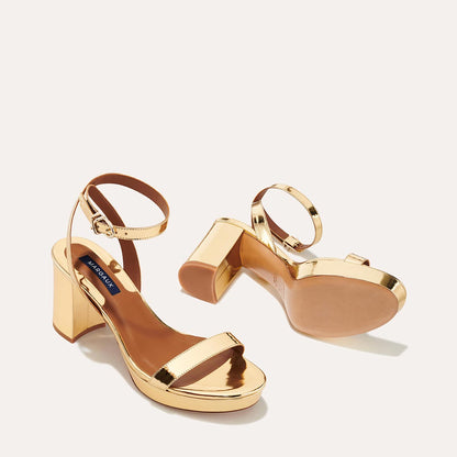 The Stella Platform in Gold Mirror, featuring a sleek strap across the toes and a comfortable 3.5-inch block heel and platform.