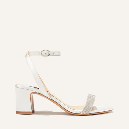 The Stella Sandal in Ivory Satin with crystal embellishment, featuring a sleek strap across the toes and a comfortable 2.5-inch breasted heel.