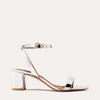 The Stella Sandal in shiny Silver Mirror, featuring a sleek strap across the toes and a comfortable 2.5-inch breasted heel.
