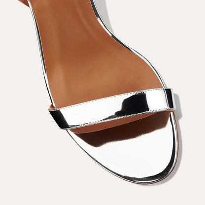 The Stella Sandal in shiny Silver Mirror, featuring a sleek strap across the toes and a comfortable 2.5-inch breasted heel.