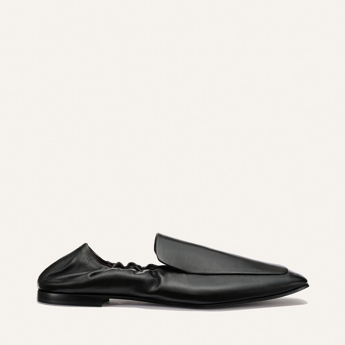 The Studio Loafer - Black Nappa by Margaux, featuring a pointed toe and a distinctive gathered ruched back, is displayed in profile against a plain white background.