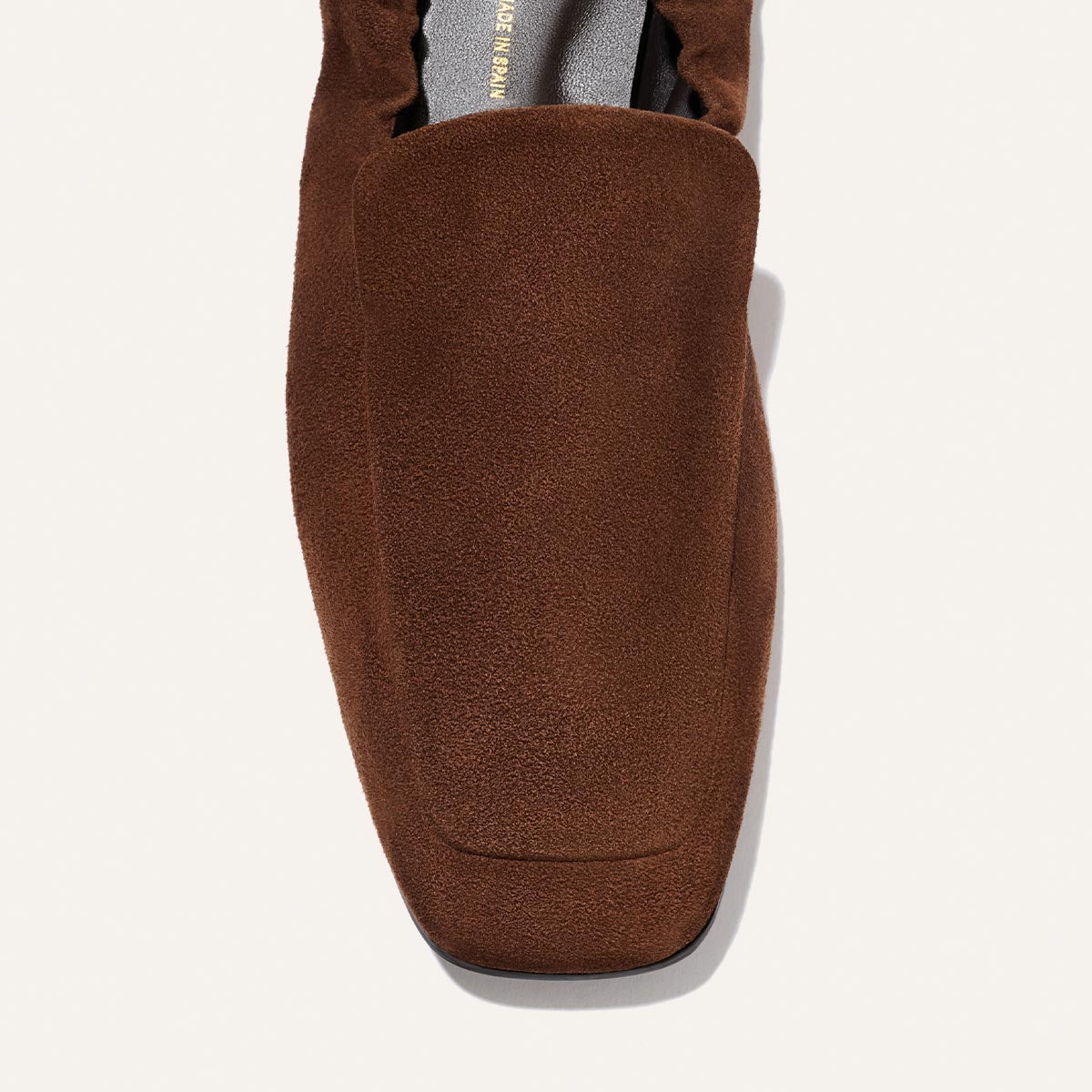 A close-up of Margaux's The Studio Loafer in Ganache Suede, featuring a square toe, shown from above on a neutral background.