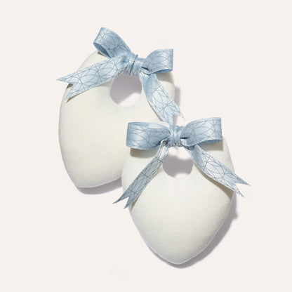 Two white, heart-shaped Canvas Shoe Shapers by Margaux, each tied with a blue geometric-patterned ribbon, are displayed on a light background—making them a charming and practical accessory for shoe care.