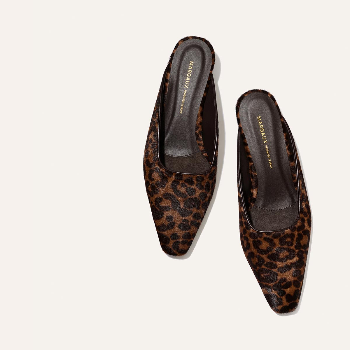 The Vesper Mule - Chocolate Leopard Haircalf by Margaux, featuring a leopard print pattern and square toes, is displayed against a plain light background.