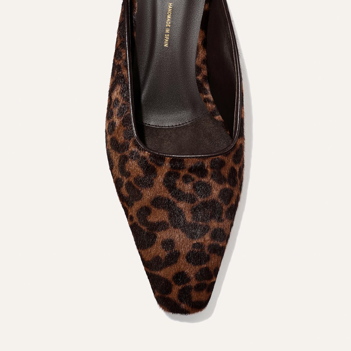 Close-up of the Margaux Vesper Mule in Chocolate Leopard Haircalf, showcasing its brown and black leopard print pattern, square toe design, and black leather insole.