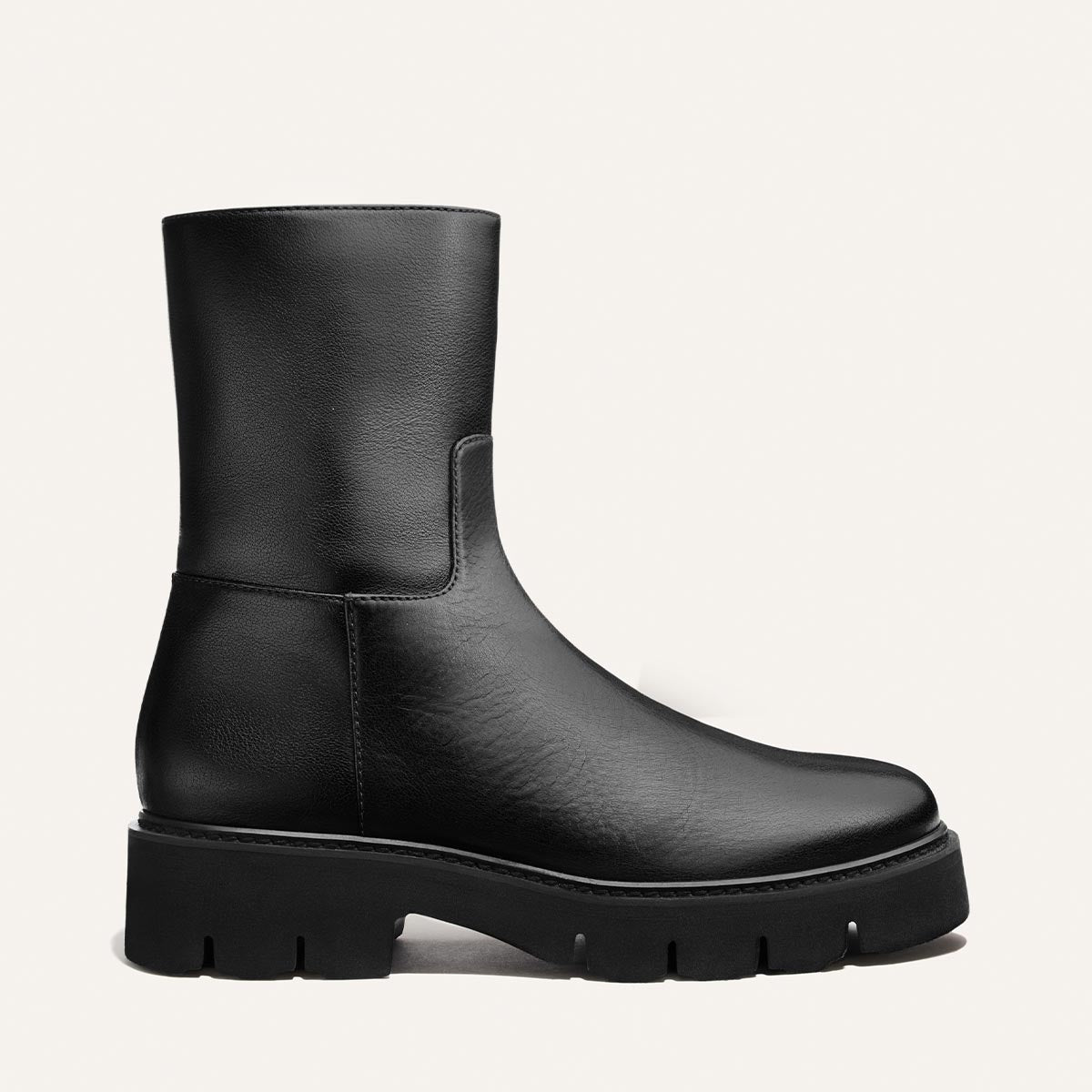 The Wells Boot - Black Calf by Margaux is a black leather mid-calf boot featuring a round toe and chunky rubber sole, displayed in side profile against a plain white background.
