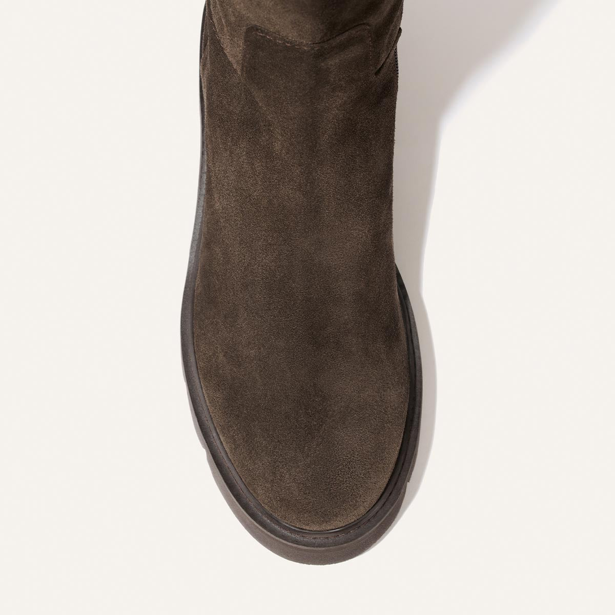 A top-down close-up of The Wells Boot - English Brown Suede, a dark brown suede ankle boot with a flat sole.