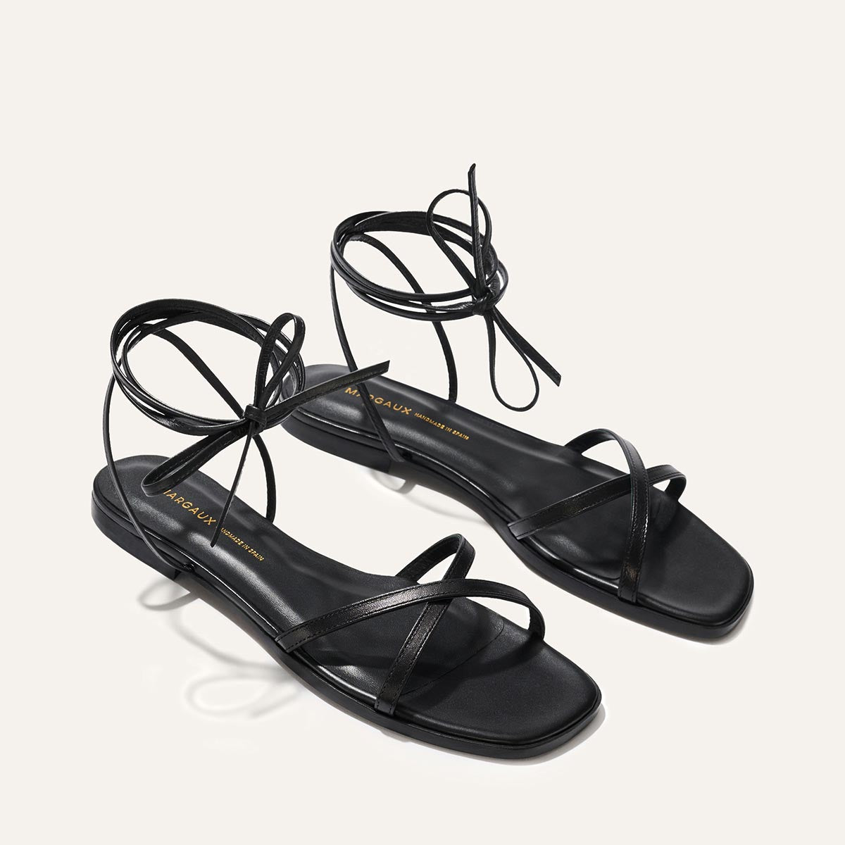 Black strappy sandals on a white background