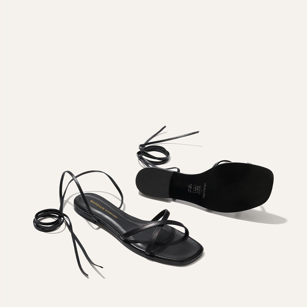 Black strappy sandals on a white background