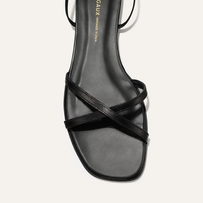 Black sandal with criss-cross straps on a white background