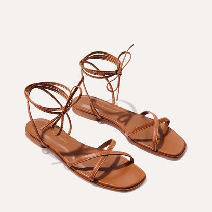 The Wrap Sandal in Saddle Nappa, a minimal sandal featuring delicate ankle wraps and a subtly squared toe.