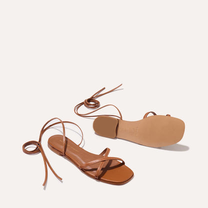 The Wrap Sandal in Saddle Nappa, a minimal sandal featuring delicate ankle wraps and a subtly squared toe.