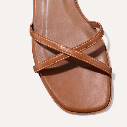 The Wrap Sandal in Saddle Nappa, a minimal sandal featuring delicate ankle wraps and a subtly squared toe.