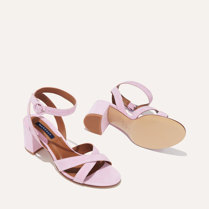 The City Sandal - Wisteria Suede by margaux-development: light pink suede heeled sandals with chunky heels, cushioned insoles, and ankle straps. Shown on a plain background, one sandal stands upright while the other shows its sole.