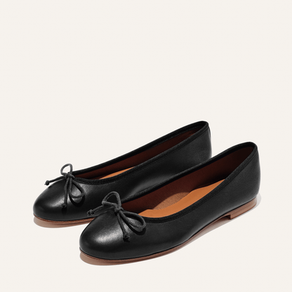 The Demi in Black Nappa, a comfortable ballet flat with a rounded toe and adjustable cord bow detail.