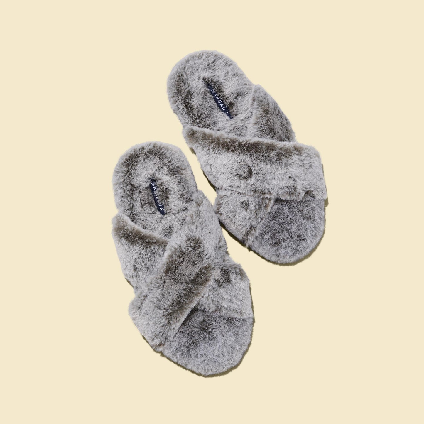 The Cozy Slipper - Grey by Margaux features a fluffy, x-strap design with open toes and is shown on a beige background.
