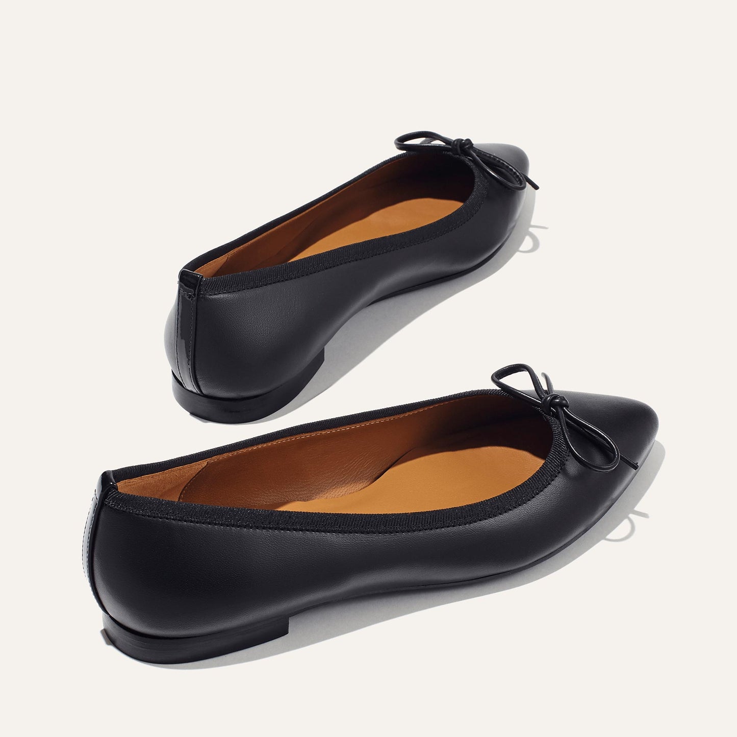 The Pointe in Black Nappa, a classic and comfortable ballet flat featuring a refined pointed toe design and decorative bow. 