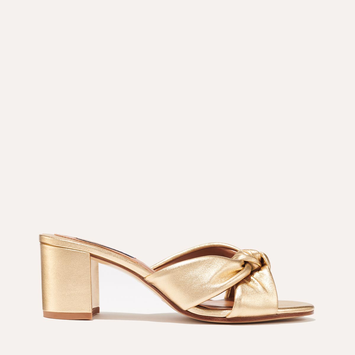 Margaux's Carmine Mule in gold nappa leather with a knot detail and comfortable block heel