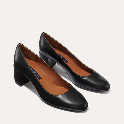 The Heel in Black Nappa, a classic block heel featuring a sleek almond toe design complemented by a comfortable 2.5-inch heel.
