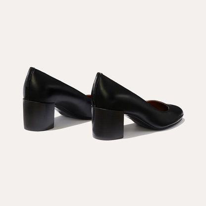 The Heel in Black Nappa, a classic block heel featuring a sleek almond toe design complemented by a comfortable 2.5-inch heel.