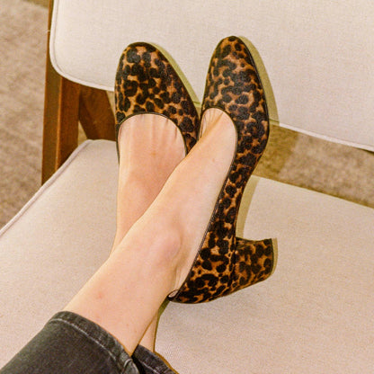 The Heel in Chocolate Leopard Haircalf, a classic block heel featuring a sleek almond toe design complemented by a comfortable 2.5-inch heel.