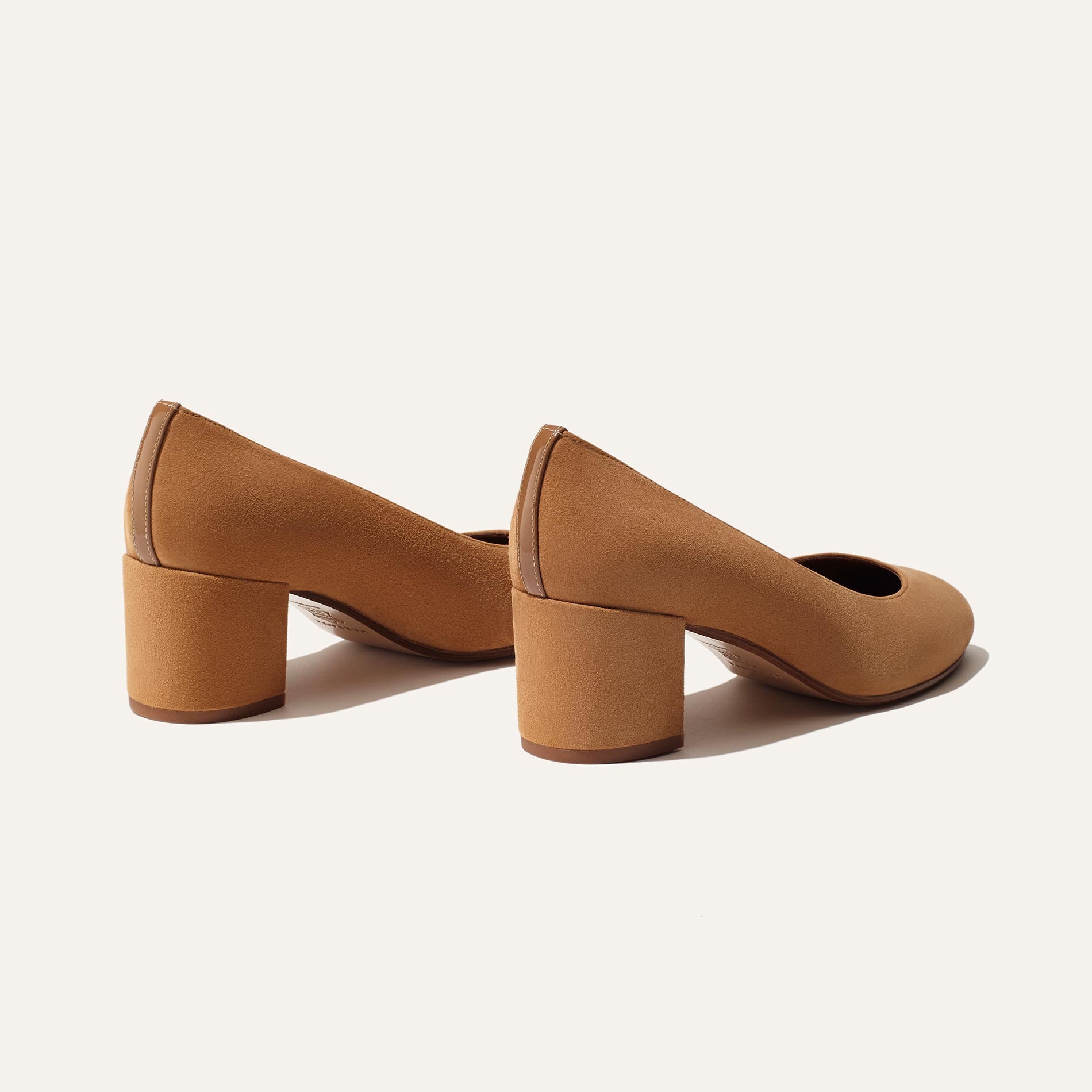 The Heel - Cacao Suede by Margaux: elegant tan suede shoes with a comfortable block heel, displayed from the back and side on a plain off-white background.