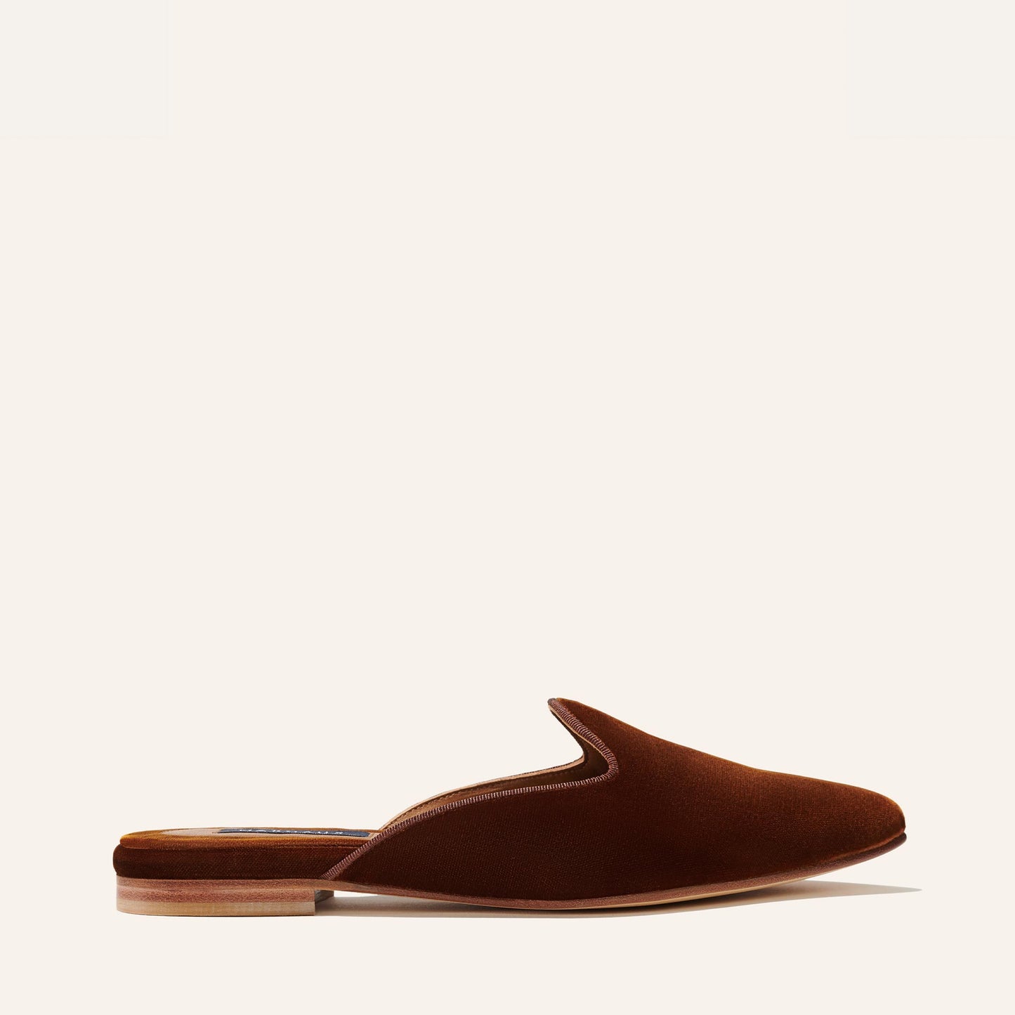 The Mule - Rust Velvet by Margaux is a comfortable slip-on with a closed toe, open back, and low wooden heel in rich velvet, shown in side view against a light background.