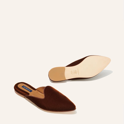 The Mule - Rust Velvet flats by Margaux: a comfortable, pointed-toe mule in brown velvet, with one shoe displayed top-up and the other showing the sole on a neutral background.