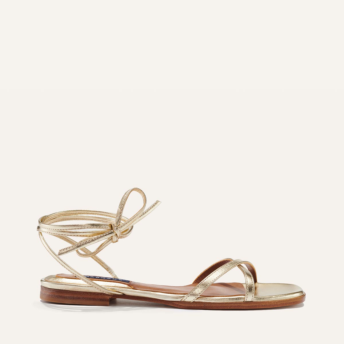 Margaux's classic strappy Wrap Sandal with ankle ties, made in Spain from soft, champagne metallic Italian nappa leather